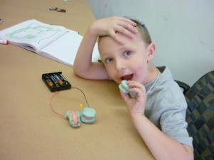 Jack plays with simple circuits, made out of conductive and insulating play dough and LED lights on electricity day of Mini Mad Scientists Camp.