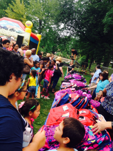 Participants anxiously wait to receive their new backpacks.